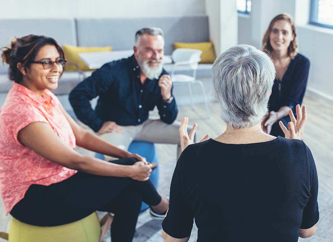 Employee Assistance Plan - Business Team Sitting in a Circle in a Large Office and Windows Discussing Employee Health and Well Being Support Tips